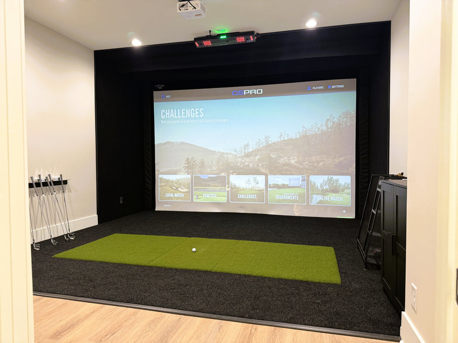 Indoor golf simulator setup with a screen displaying a golf course.