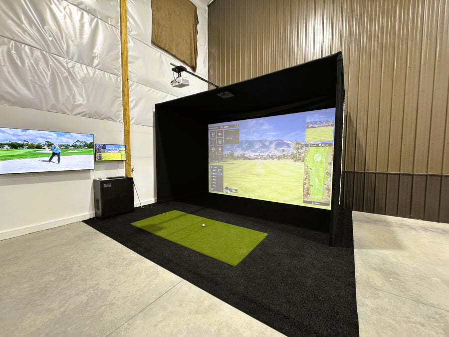 Indoor golf simulator setup with multiple screens displaying a golf course.
