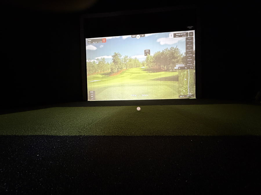 Golf simulator screen displaying a golf course on a dark background