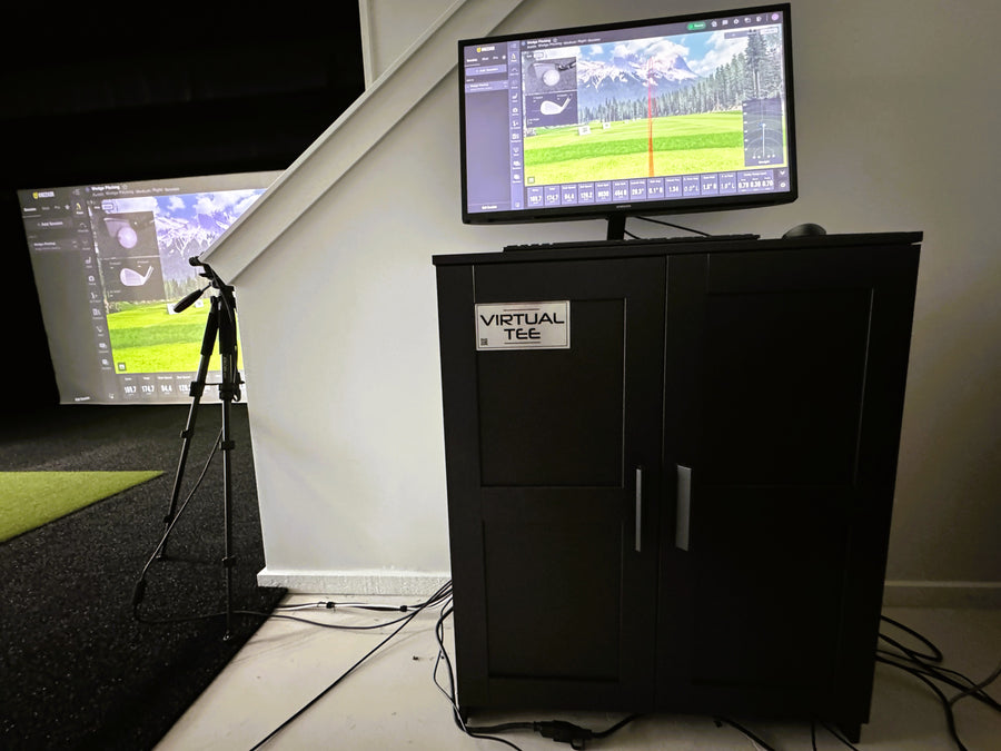 Golf simulator setup with screen, virtual tee machine, and projection on wall.