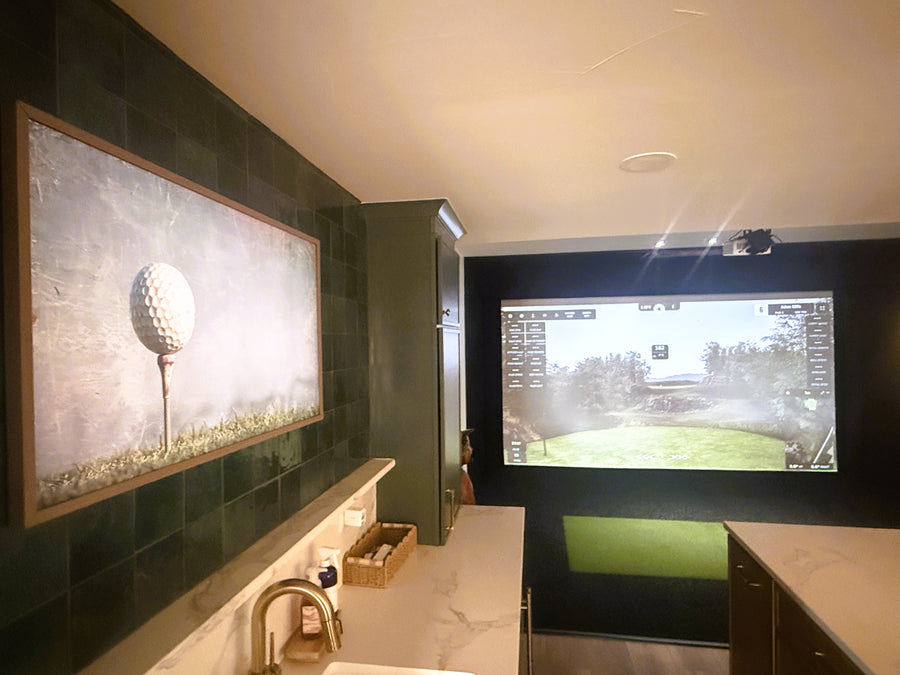 Golf-themed bathroom with a golf simulator screen displaying a golf course.