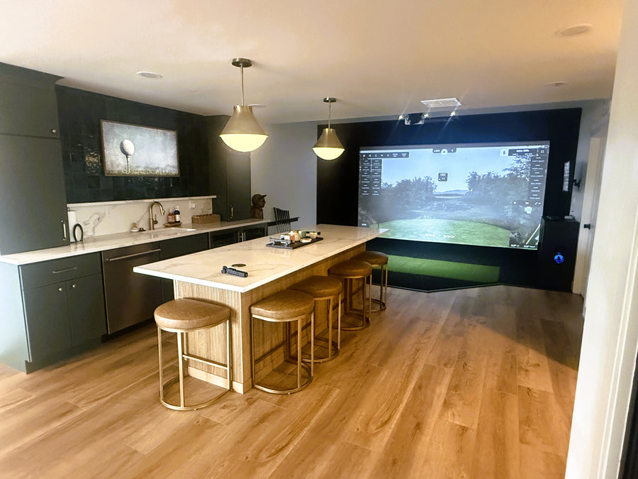Modern kitchen with a golf simulator screen displaying a golf simulation game.