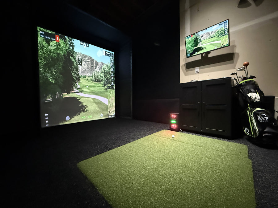 Indoor golf simulator setup with screens displaying a golf course.