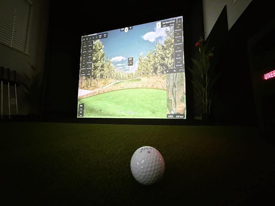 Golf ball on a simulator screen displaying a golf course