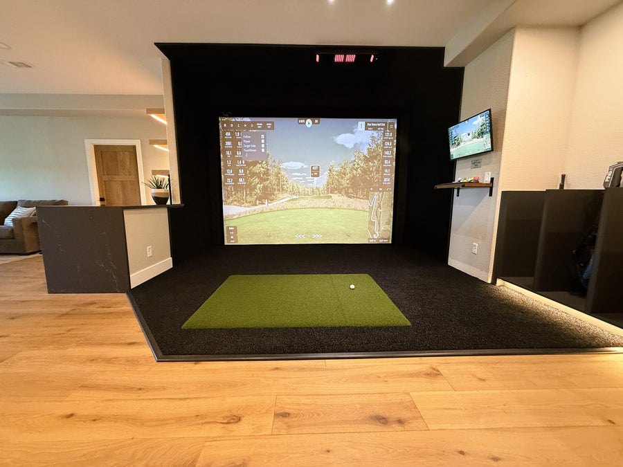 Indoor golf simulator setup in a living room with a screen displaying a golf course.