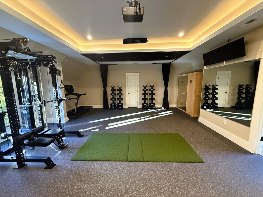 Retractable Golf Simulator and Gym with exercise equipment, green mat, and mirrors on the wall.