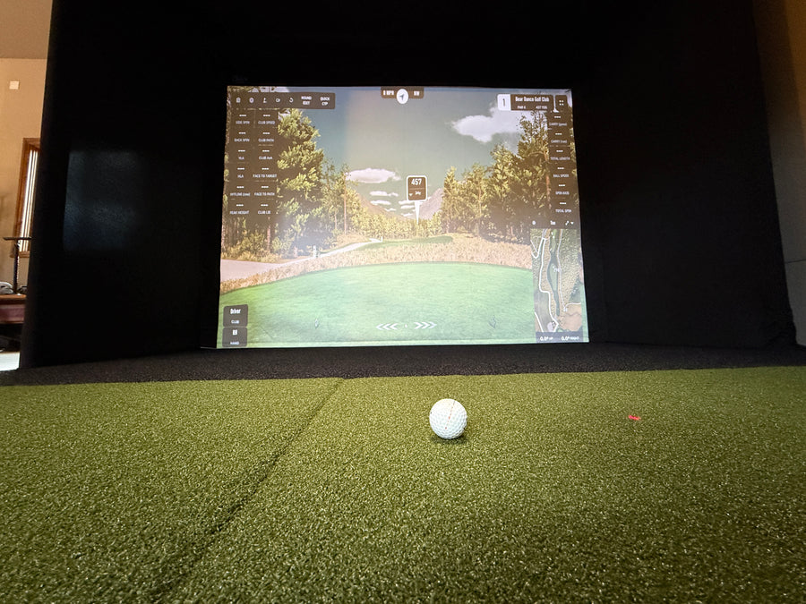 Golf simulator with a screen displaying a golf course.