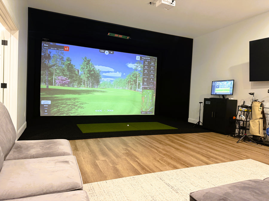 Golf simulator setup in a living room with a large screen displaying a golf game.