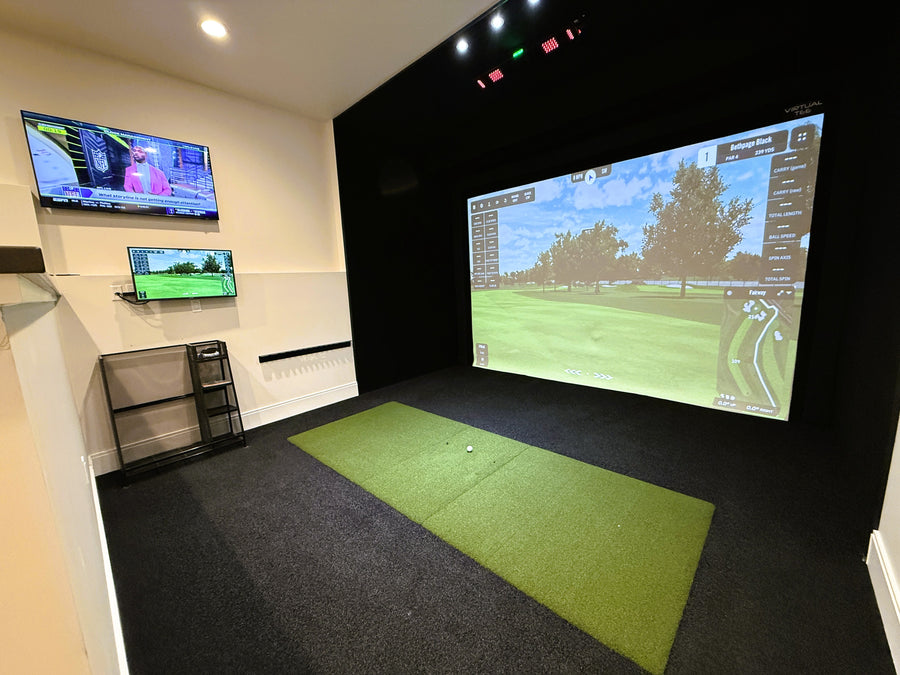 Golf simulator setup with large screen and green mat on floor