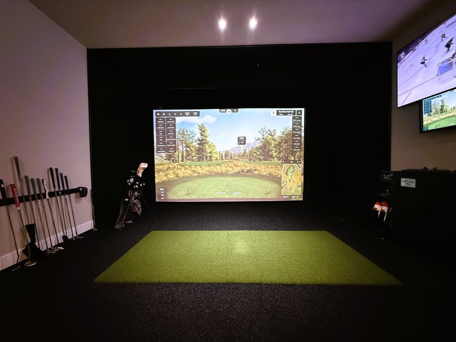 Indoor golf simulator setup with two screens displaying golf games.