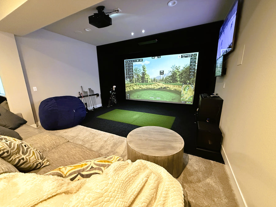 Living room with a golf simulator setup featuring a large screen displaying a golf game.