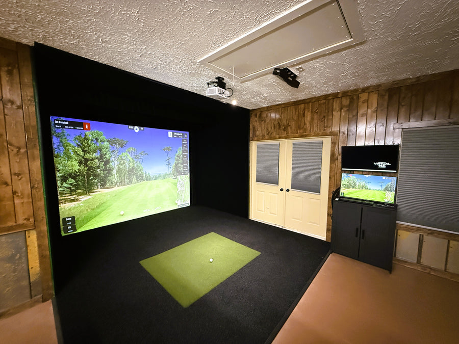 Golf simulator room with two monitors displaying a golf course.