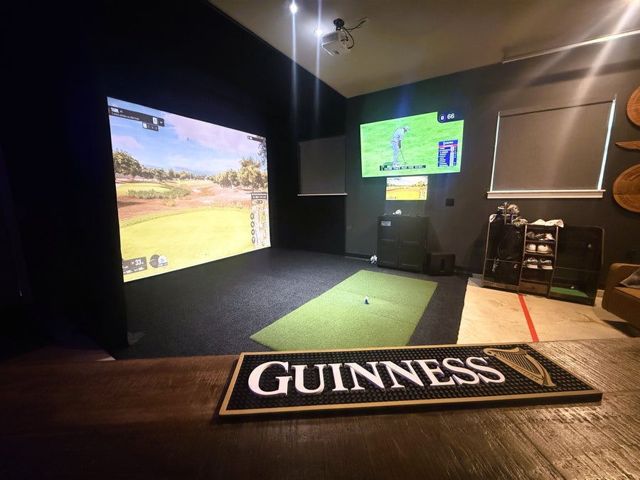 Custom golf simulator with screen displaying golf round and green turd on the floor.