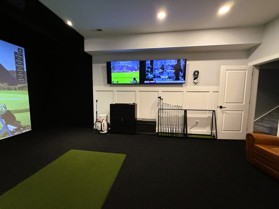 Golf simulator setup in a room with multiple screens displaying golf games.