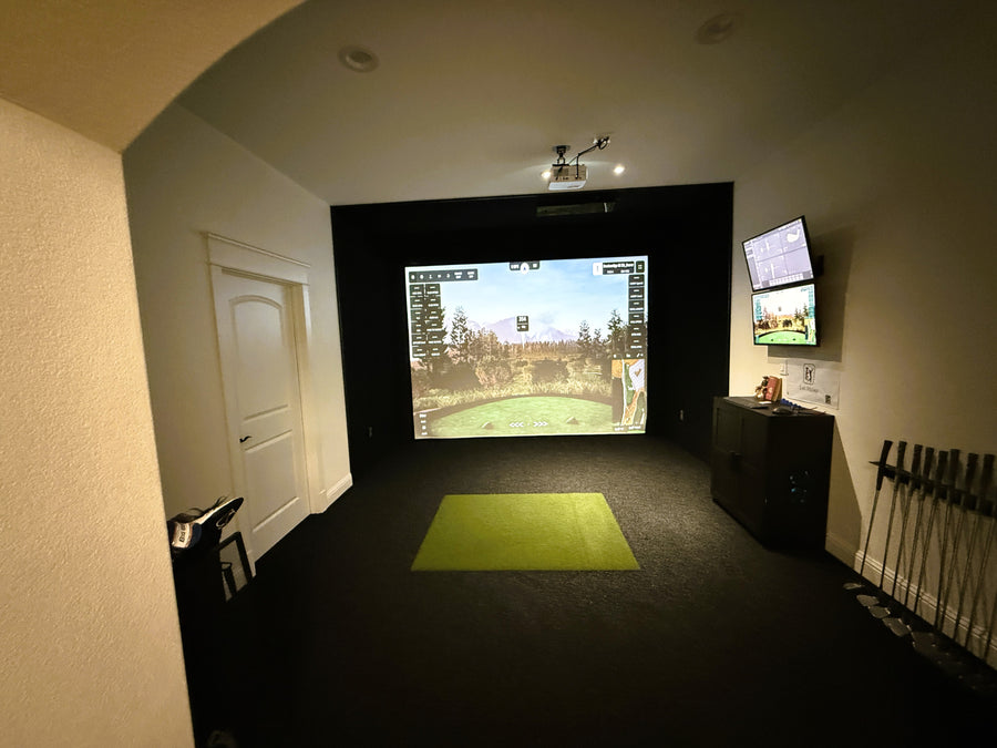 Golf simulator room with screens displaying a golf course.
