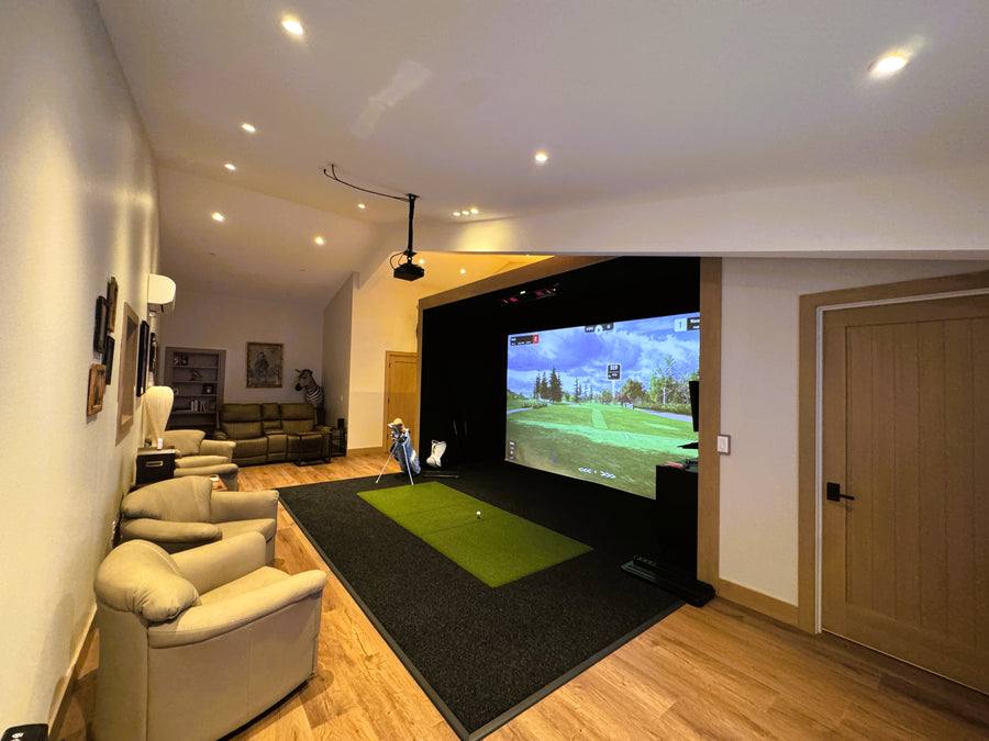 Indoor golf simulator setup in a living room with a screen displaying a golf course.