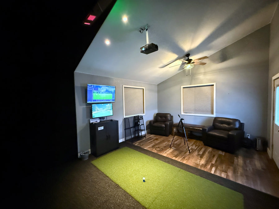 Indoor golf simulator with electronic score display in a home setting