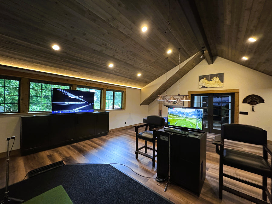 Modern home theater with large screen TV and gaming setup.