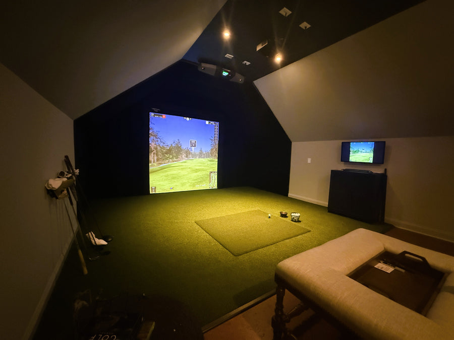 Indoor golf simulator setup with a screen displaying a golf course.
