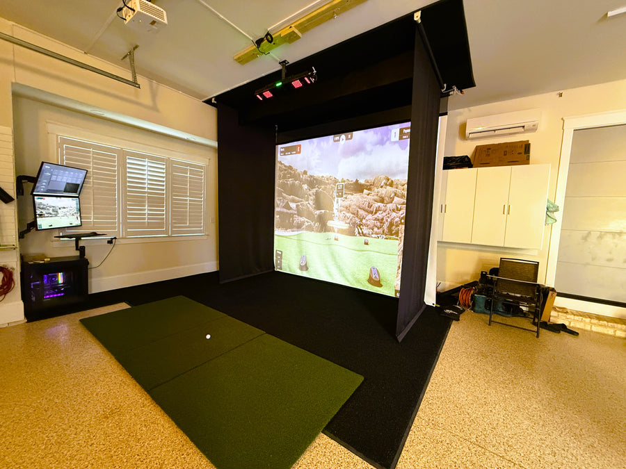 Indoor golf simulator setup with screen displaying a golf course.