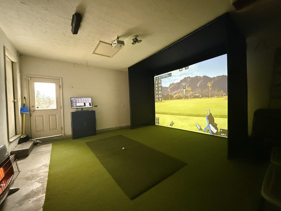 Indoor golf simulator setup with a screen displaying a golf course.