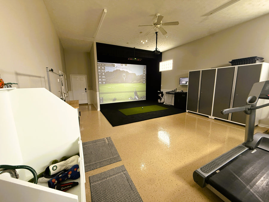 Home gym with treadmill, weight bench, and golf simulator in a room.