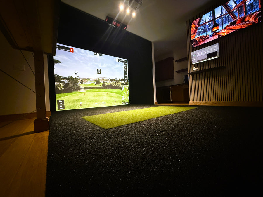 Indoor golf simulator setup with two screens displaying a golf course.