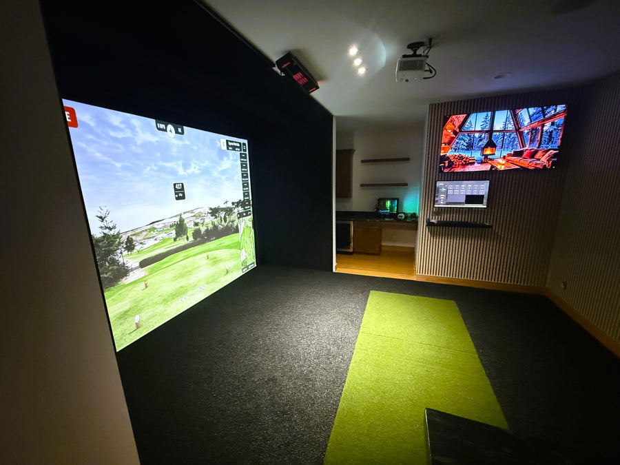 Indoor golf simulator setup with two screens displaying virtual golf environments.