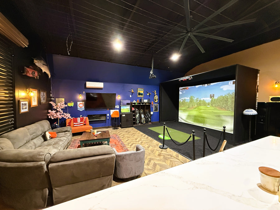 Garage golf simulator set up with lounge area. 