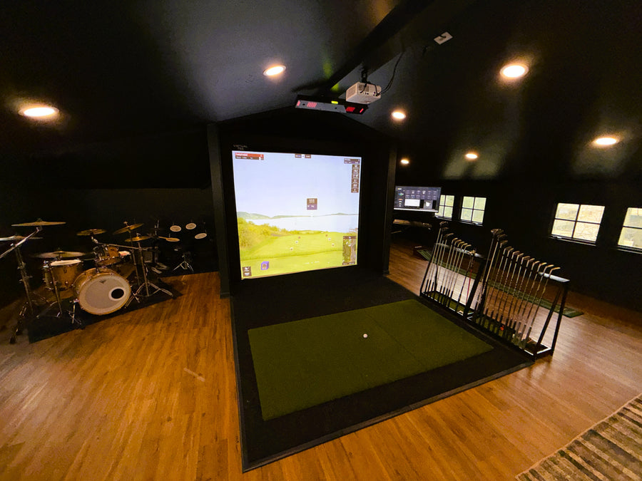 Garage loft area with a golf simulator, drum set, and seating.