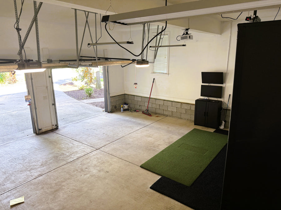 Garage golf simulator setup, including a screen and equipment.