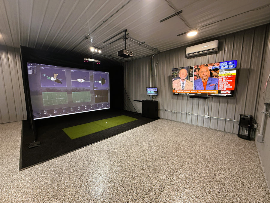 Golf simulator room with TV mounted to the wall and displaying a sports center show. 