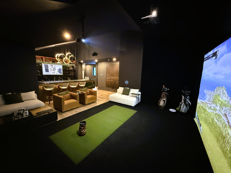 Indoor golf simulator setup in a living room with a screen displaying a golf course.