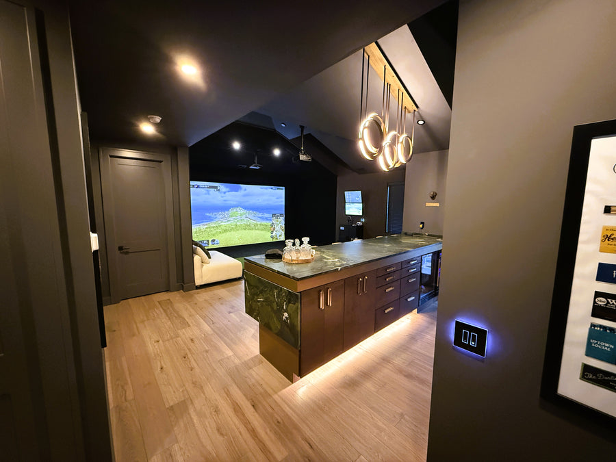 Indoor golf simulator, wooden flooring, and stylish pendant lights.
