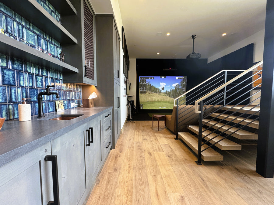 Modern kitchen looking into a golf simulator space.
