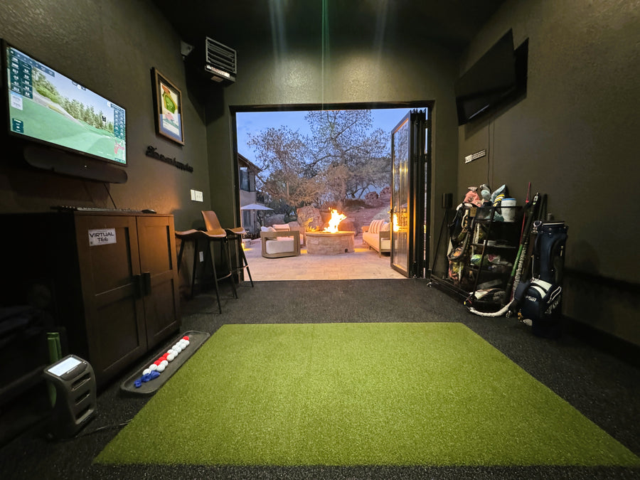 Indoor golf simulator setup in a room with a TV and outdoor view.
