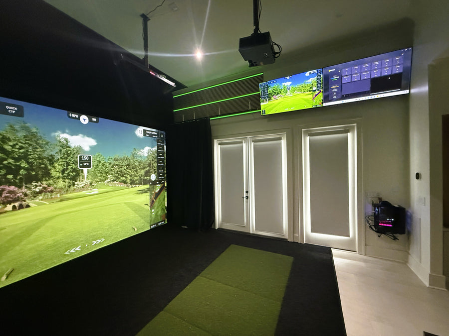 Indoor golf simulator setup with two screens displaying a golf course.