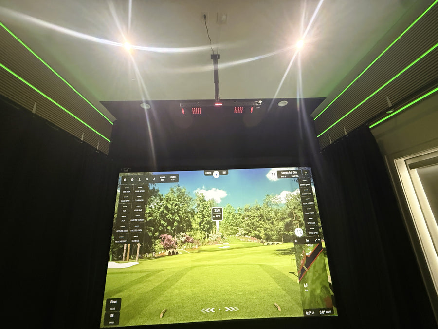 Indoor golf simulator setup with a screen displaying a golf course.