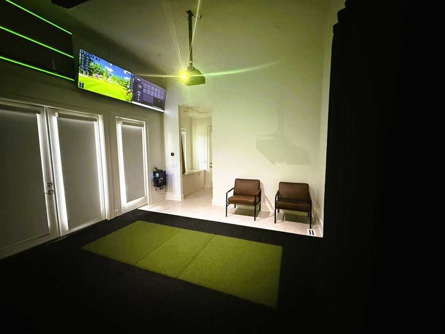 Indoor golf simulator setup with TV screen displaying a golf course.
