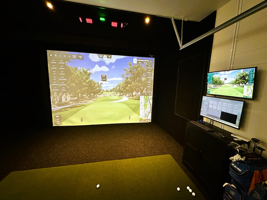 Golf simulator setup with two screens displaying a golf course.