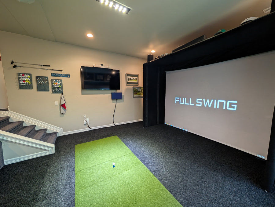 Indoor golf simulator setup with screen displaying 'FULL SWING' in a room.