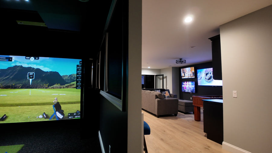 Golf simulator setup with multiple TVs displaying different scenes.