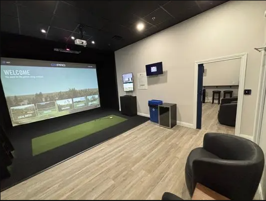 Golf simulator room with projection screen and chairs